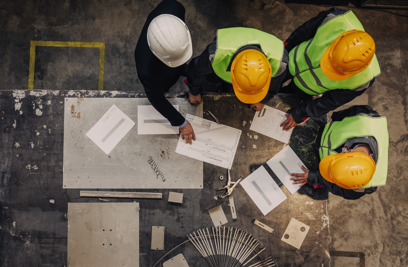 Construction team reviewing plans together around a project work table