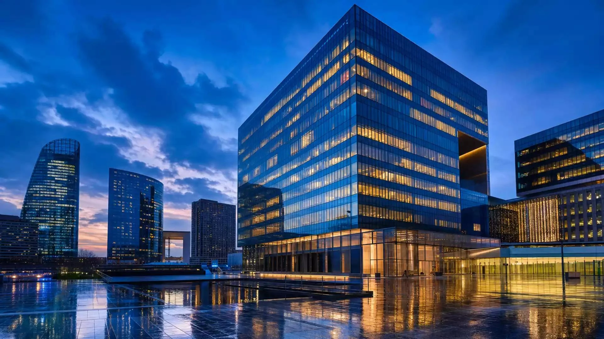 Modern glass office buildings illuminated at dusk