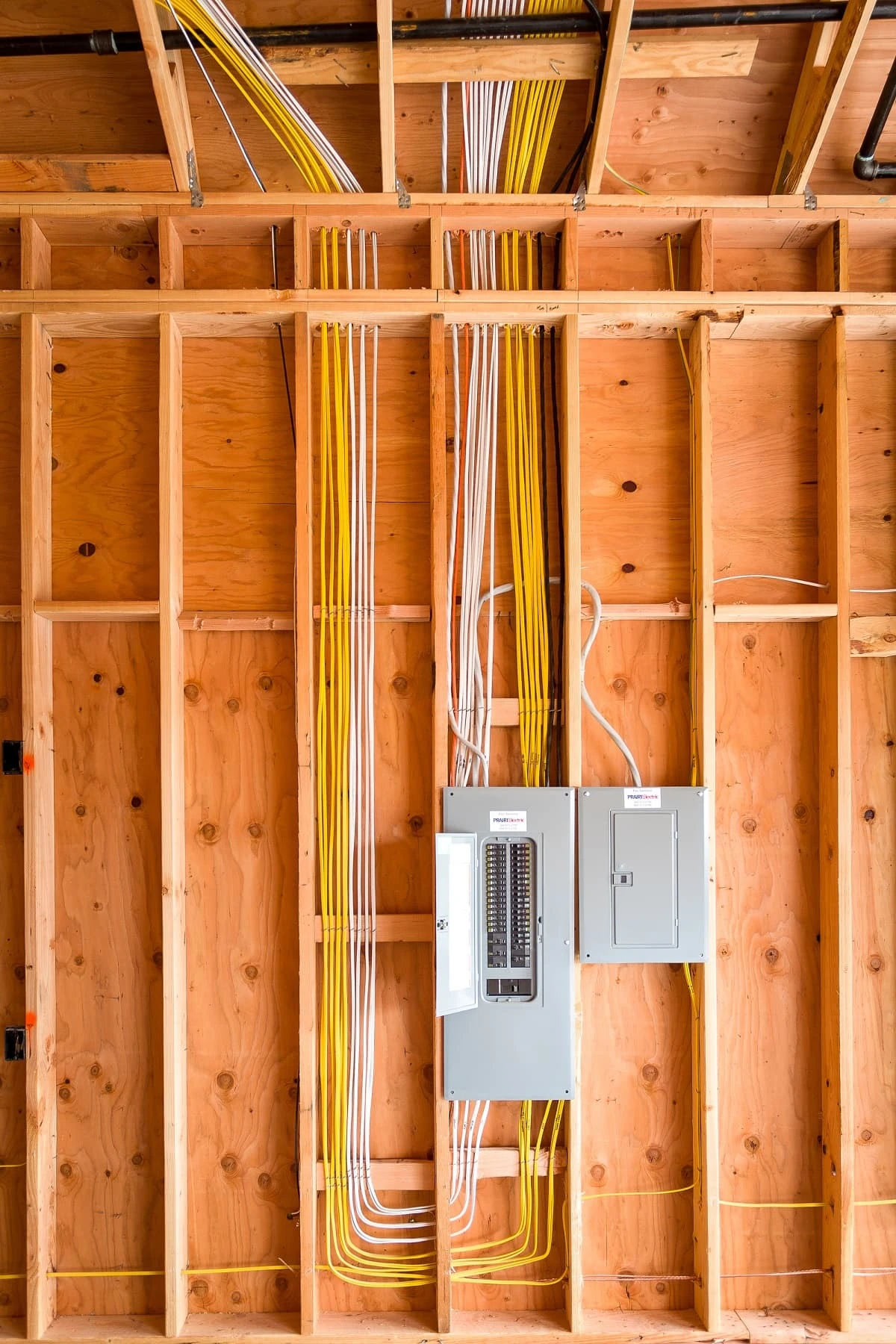 Electrical wiring routed through exposed framing into a breaker panel